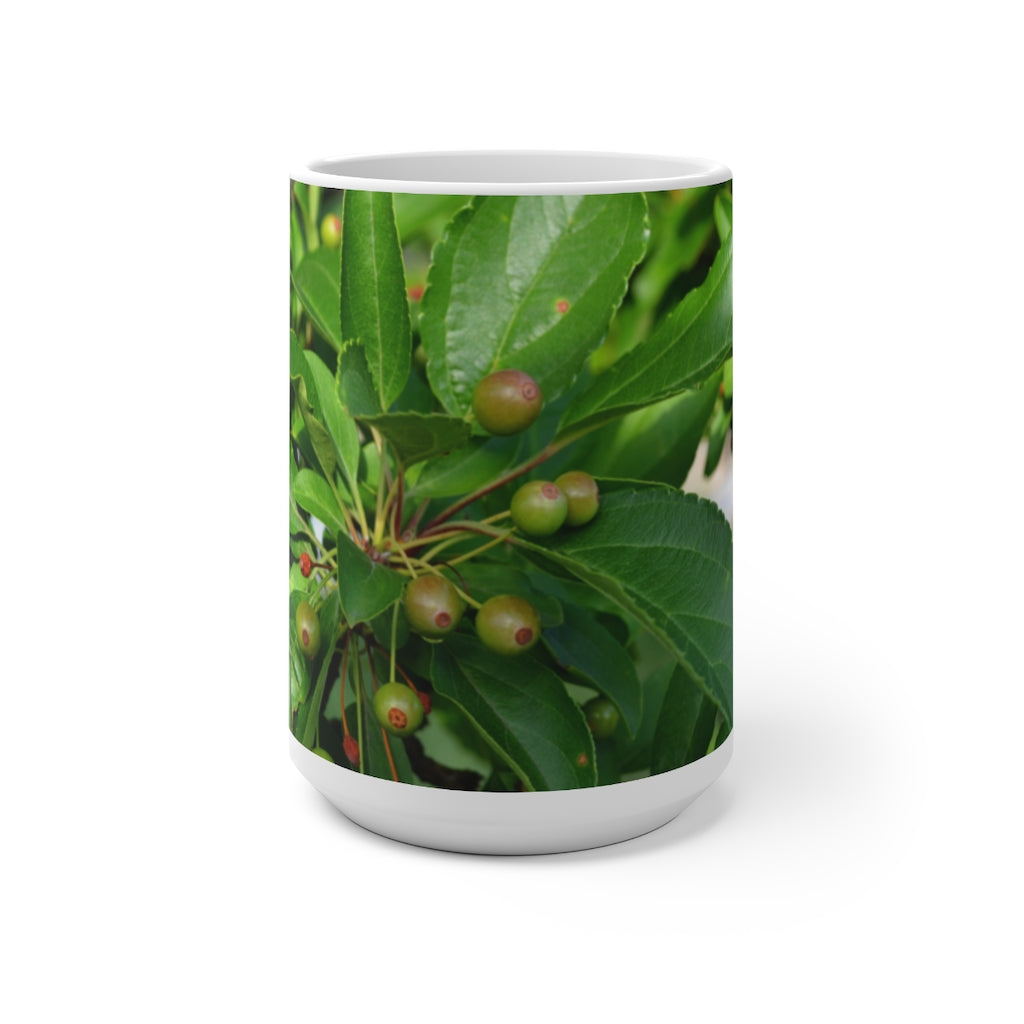 A white ceramic mug with seeds and green leaves design that changes color when filled with hot liquid, showcasing its unique feature.