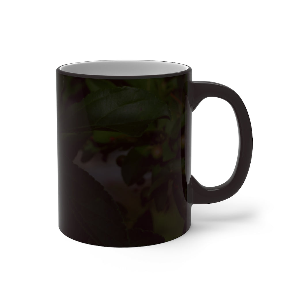 A white ceramic mug with seeds and green leaves design that changes color when filled with hot liquid, showcasing its unique feature.