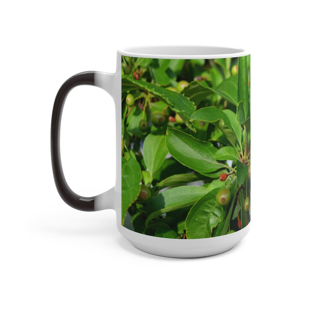 A white ceramic mug with seeds and green leaves design that changes color when filled with hot liquid, showcasing its unique feature.