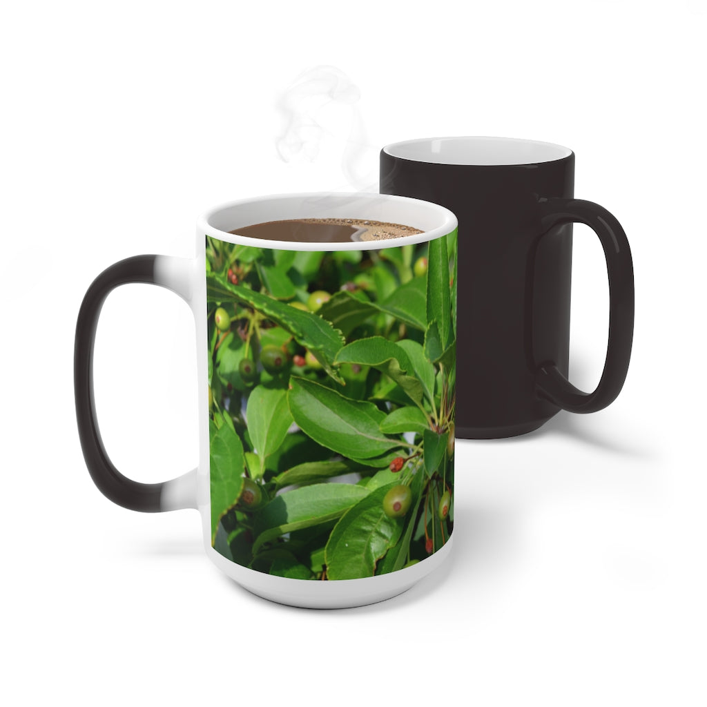 A white ceramic mug with seeds and green leaves design that changes color when filled with hot liquid, showcasing its unique feature.