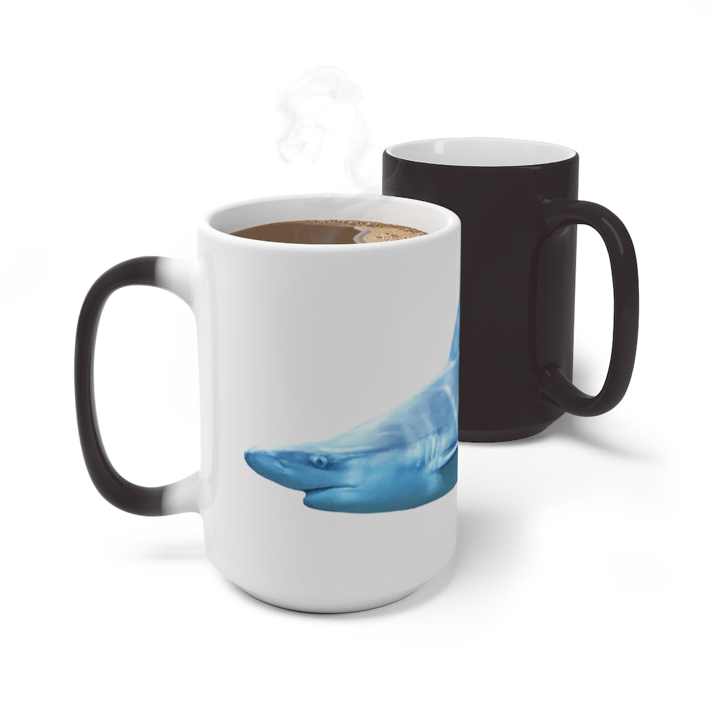 A white ceramic mug featuring a shark design that changes color when filled with hot liquid, showcasing its playful and magical feature.