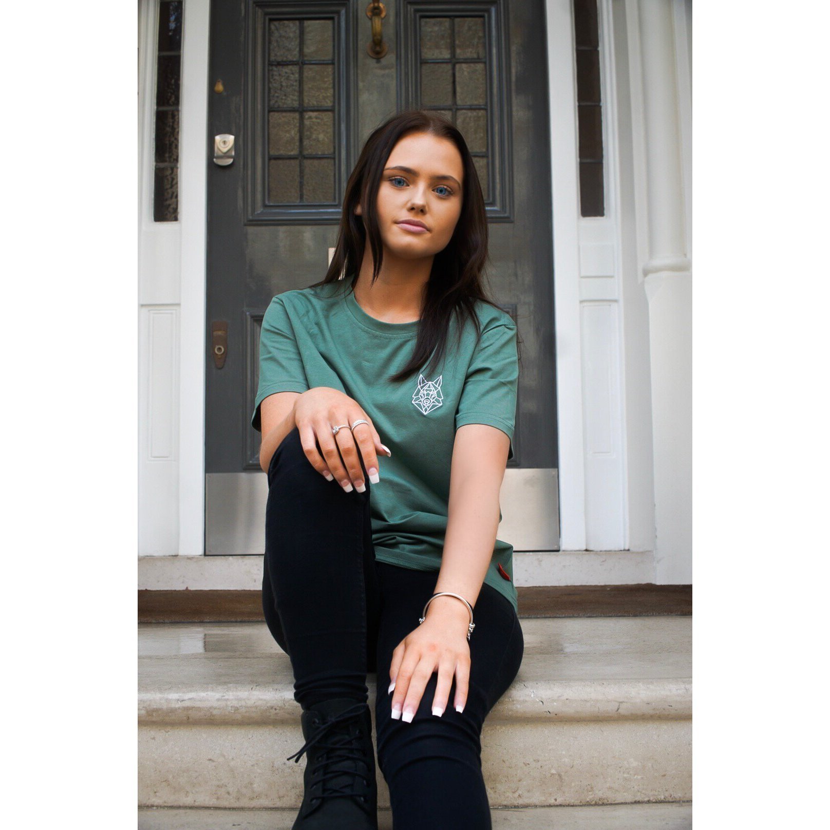 A fitted green T-shirt featuring a white embroidered Wolfe logo on the left chest, made from soft cotton and spandex.