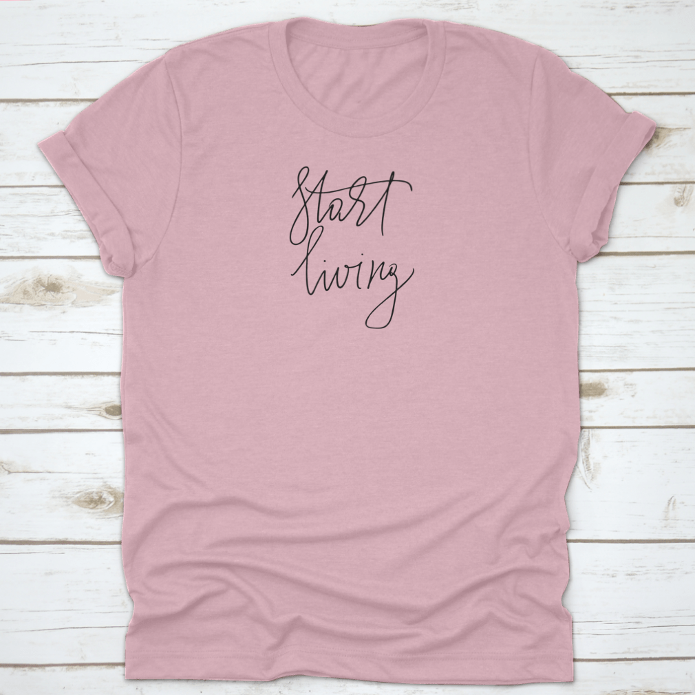 A stylish t-shirt featuring the cursive text 'Start Living' printed on the front, made from soft cotton fabric.