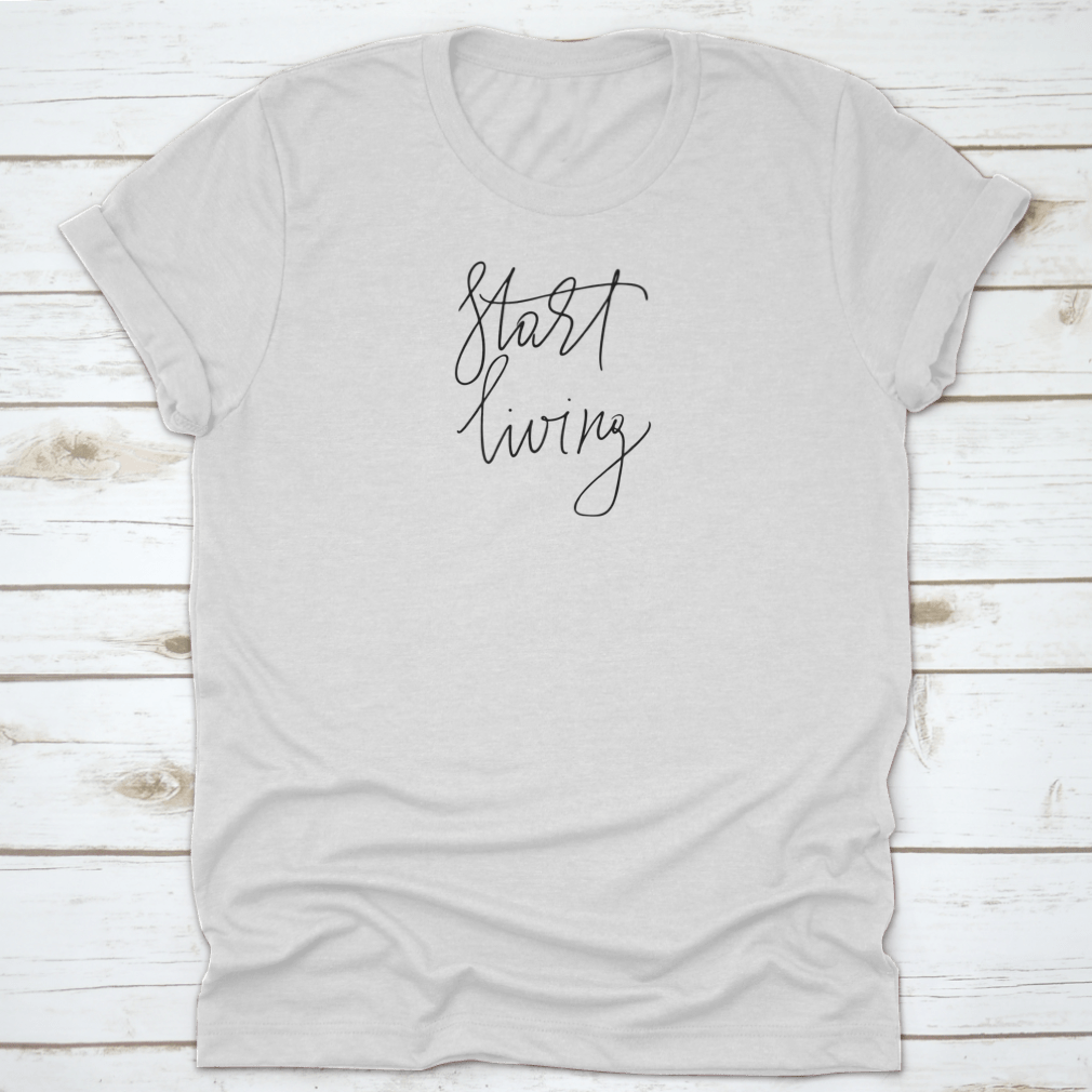 A stylish t-shirt featuring the cursive text 'Start Living' printed on the front, made from soft cotton fabric.