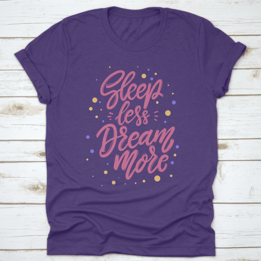 A stylish T-shirt featuring the phrase 'Sleep Less Dream More' in a cute lettering design, made from 100% cotton for comfort.