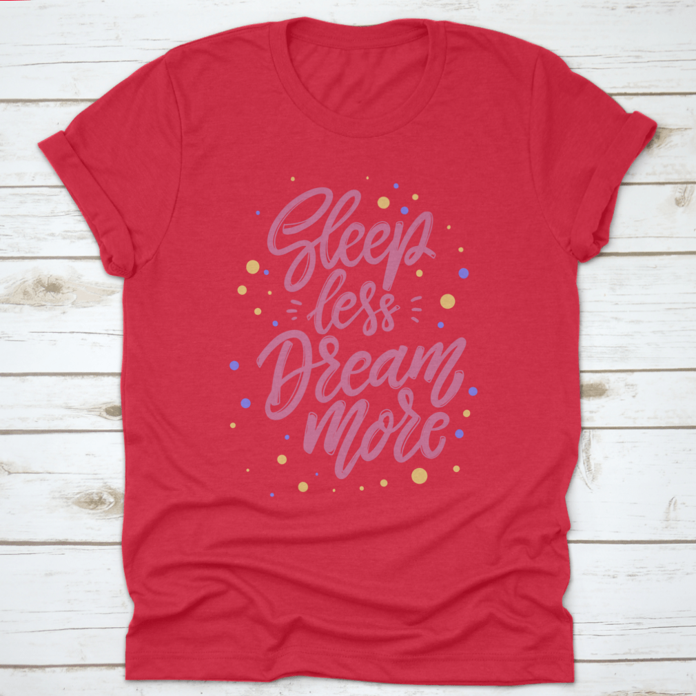 A stylish T-shirt featuring the phrase 'Sleep Less Dream More' in a cute lettering design, made from 100% cotton for comfort.