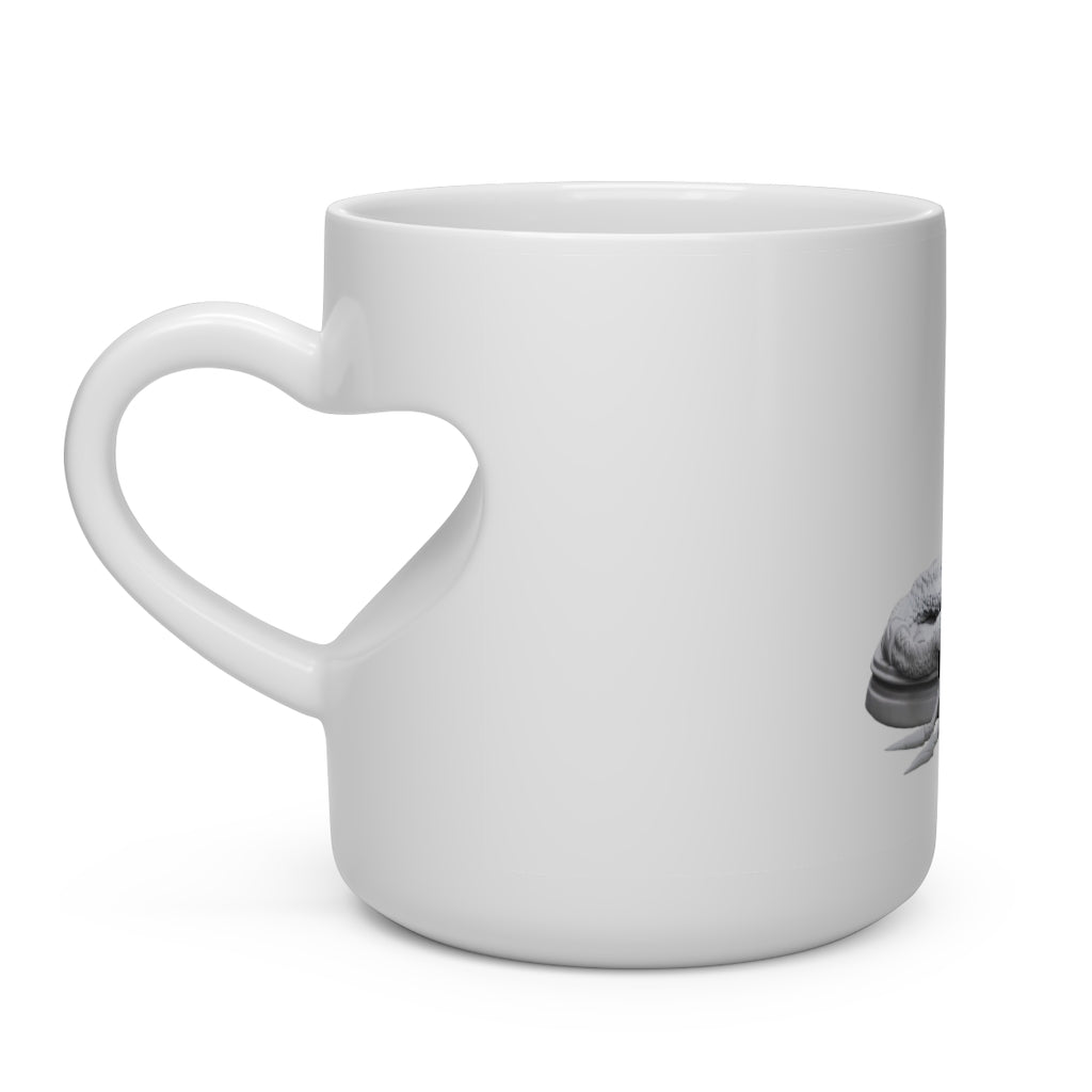 A white ceramic mug shaped like a heart with a snake design on the handle, perfect for hot beverages.