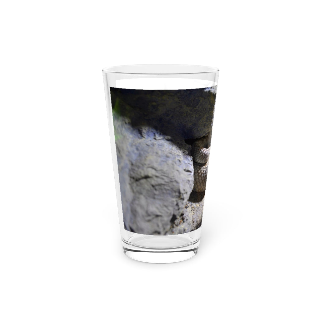 A clear 16oz Snake Pint Glass showcasing a custom printed design, perfect for beverages.