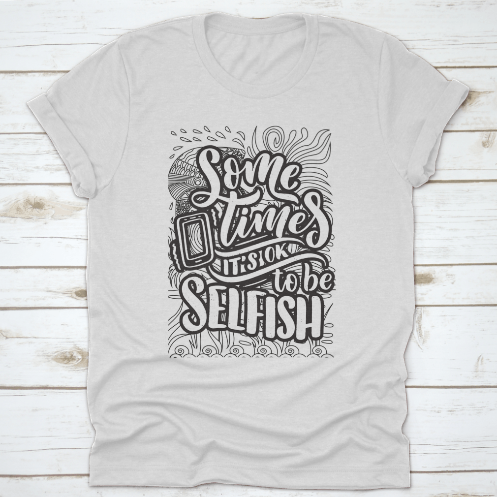 A stylish grey T-shirt featuring the inspirational quote 'Sometimes It's Okay To Be Selfish' in bold lettering, made from soft cotton fabric.