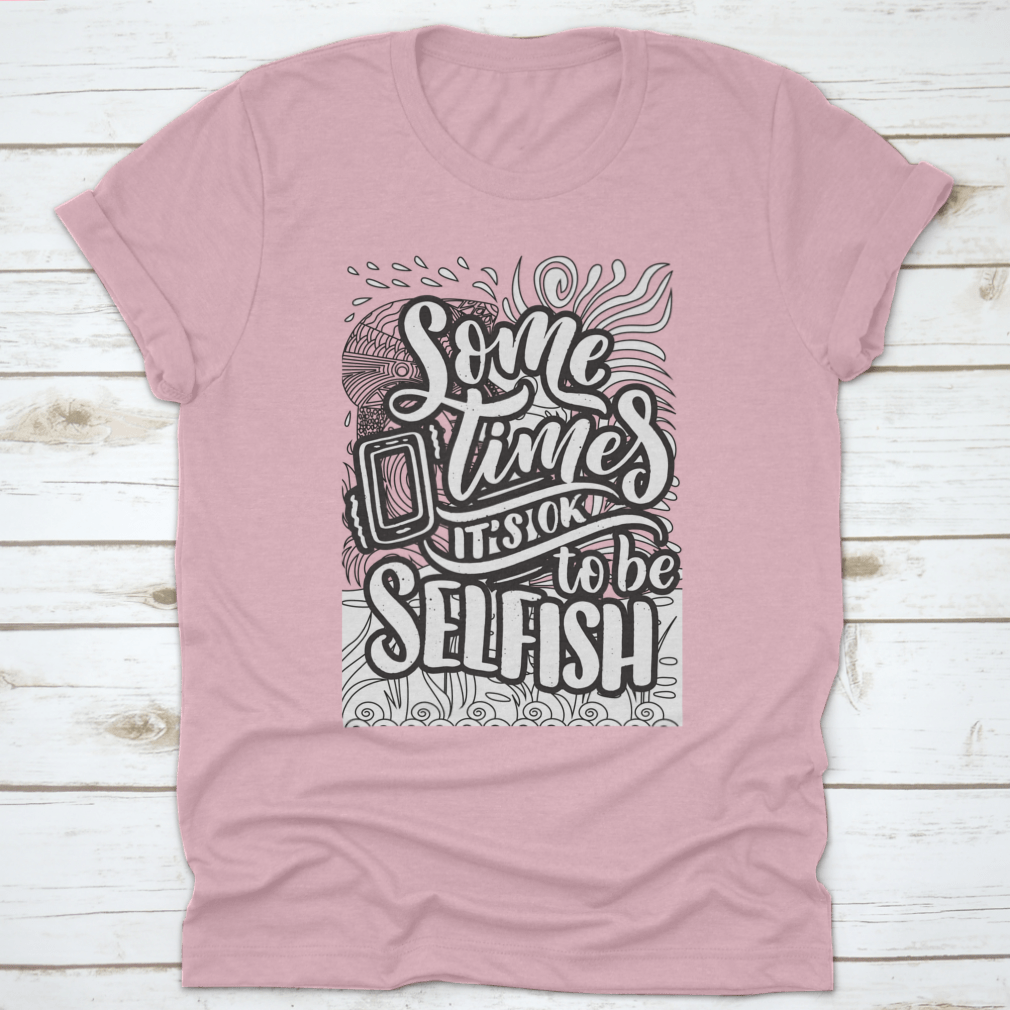 A stylish grey T-shirt featuring the inspirational quote 'Sometimes It's Okay To Be Selfish' in bold lettering, made from soft cotton fabric.