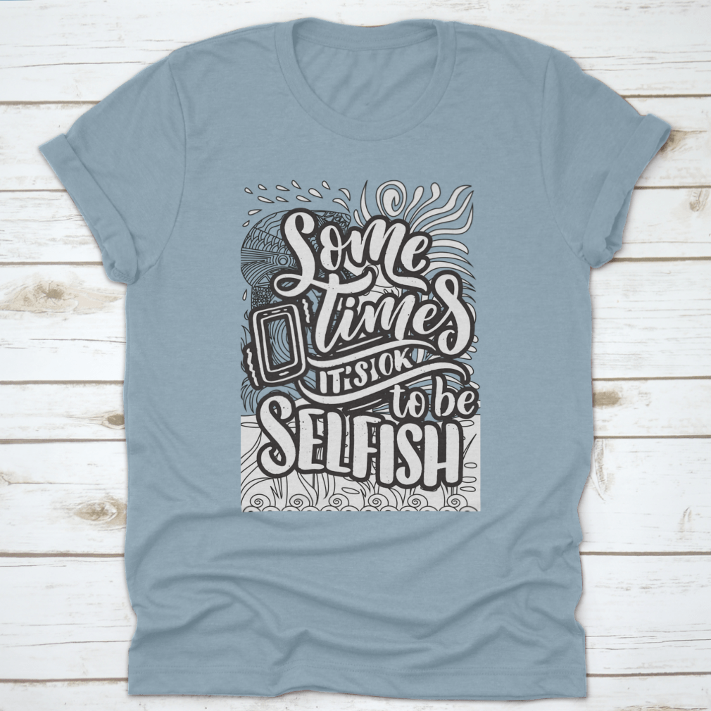 A stylish grey T-shirt featuring the inspirational quote 'Sometimes It's Okay To Be Selfish' in bold lettering, made from soft cotton fabric.