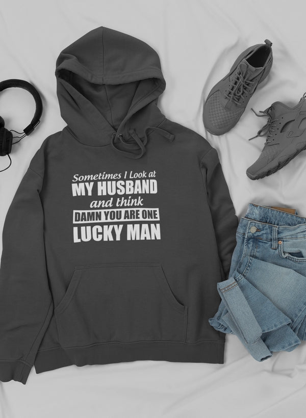 A cozy hoodie featuring the quote 'Sometimes I Look At My Husband and Think Damn You Are One Lucky Man', designed by top artists.