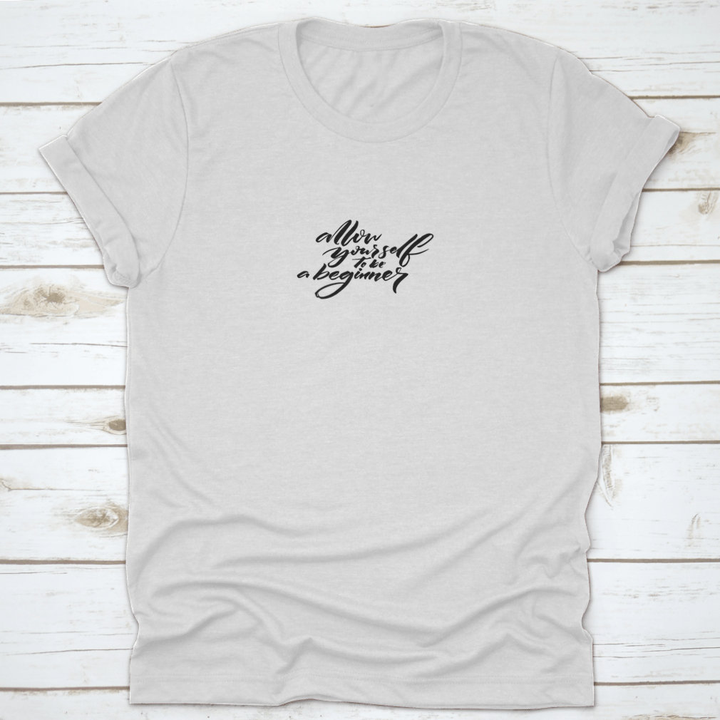 A comfortable cotton t-shirt featuring the motivational quote 'Allow Yourself To Be A Beginner' in a stylish font, perfect for inspiring beginners.