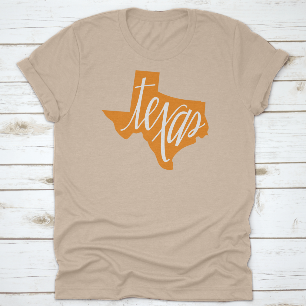 A stylish Texas State Outline and Hand Lettering Shirt, showcasing a unique design on a comfortable cotton fabric.