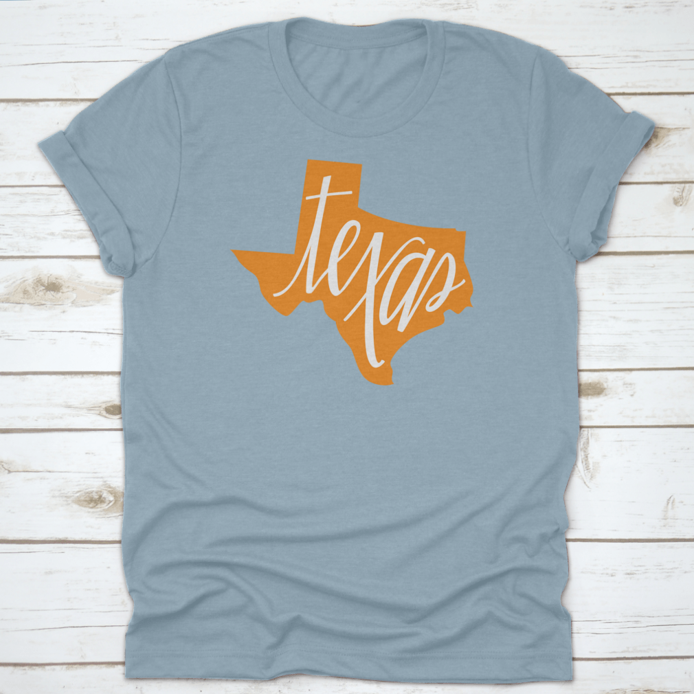 A stylish Texas State Outline and Hand Lettering Shirt, showcasing a unique design on a comfortable cotton fabric.