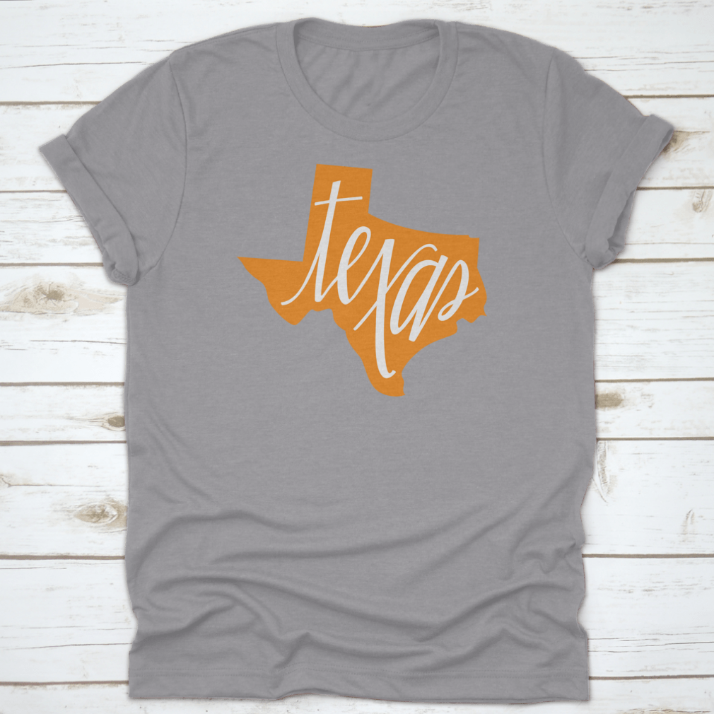 A stylish Texas State Outline and Hand Lettering Shirt, showcasing a unique design on a comfortable cotton fabric.