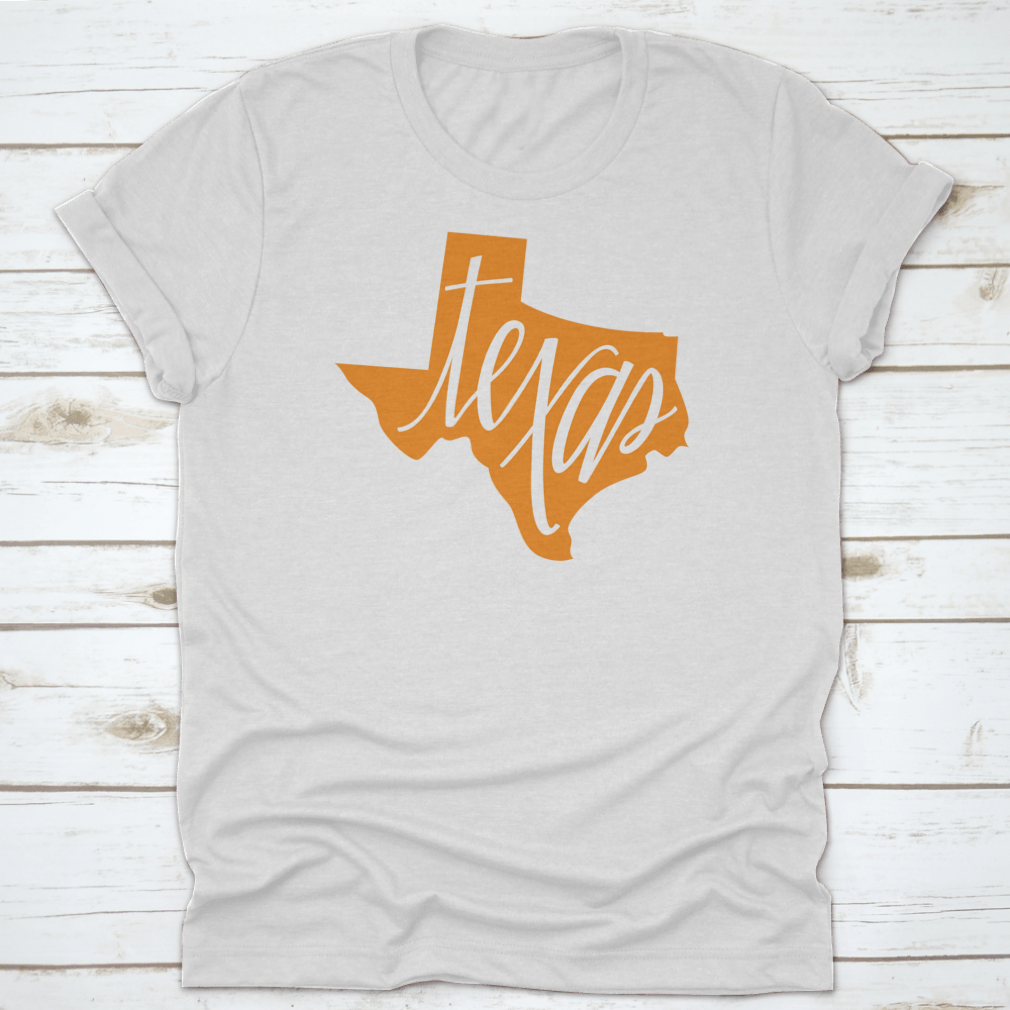 A stylish Texas State Outline and Hand Lettering Shirt, showcasing a unique design on a comfortable cotton fabric.