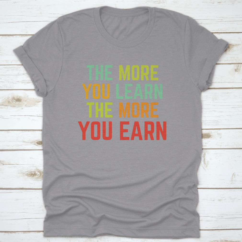 A comfortable and stylish t-shirt featuring the phrase 'The More You Learn', made from 100% cotton with a classic fit.