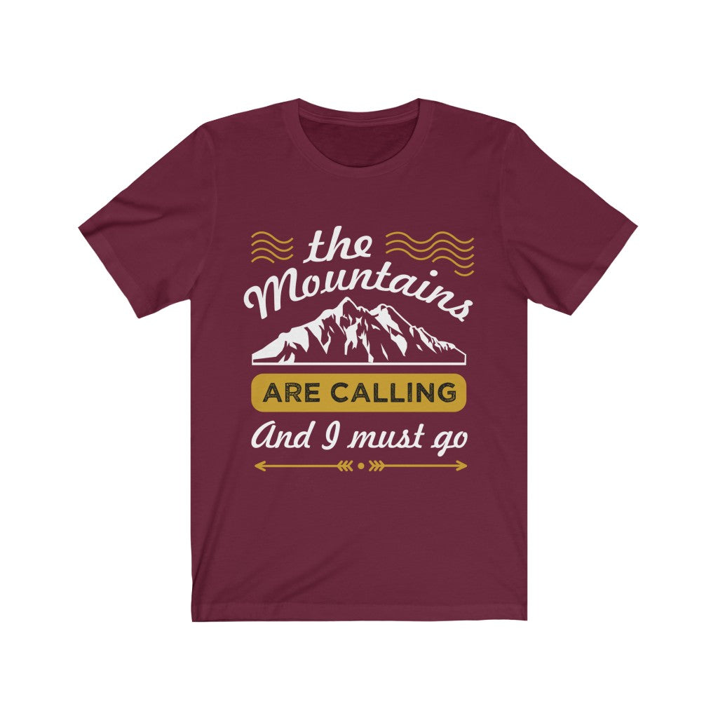 A unisex T-shirt featuring the phrase 'The Mountains are Calling' in a stylish vinyl print, made from 100% soft cotton.