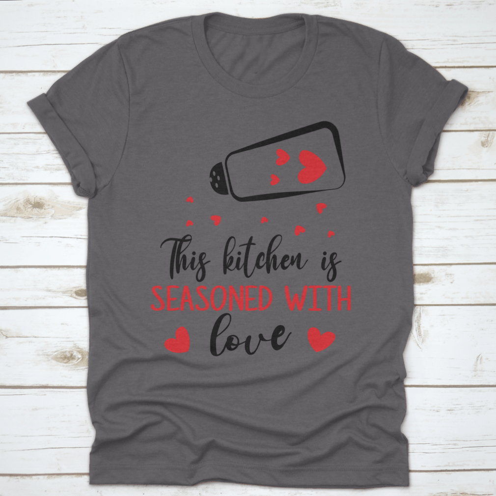 A stylish t-shirt featuring the quote 'This Kitchen Is Seasoned With Love', made from soft cotton fabric, perfect for cooking enthusiasts.