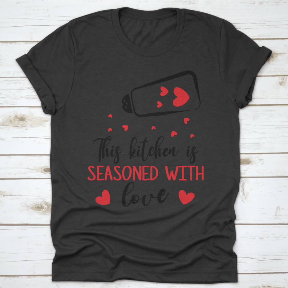 A stylish t-shirt featuring the quote 'This Kitchen Is Seasoned With Love', made from soft cotton fabric, perfect for cooking enthusiasts.