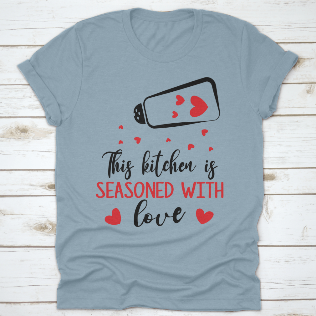 A stylish t-shirt featuring the quote 'This Kitchen Is Seasoned With Love', made from soft cotton fabric, perfect for cooking enthusiasts.