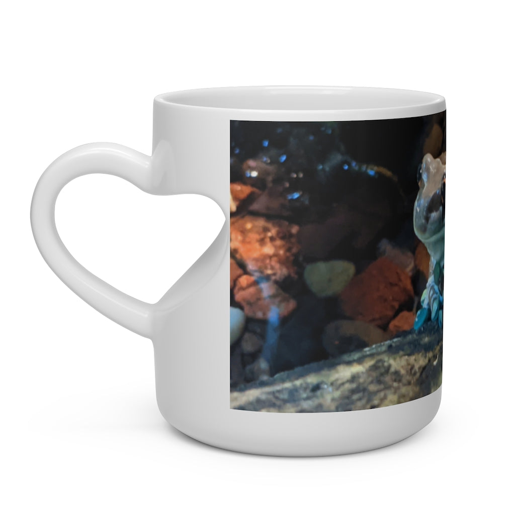 A white ceramic mug shaped like a heart with a heart-shaped handle, perfect for hot beverages.