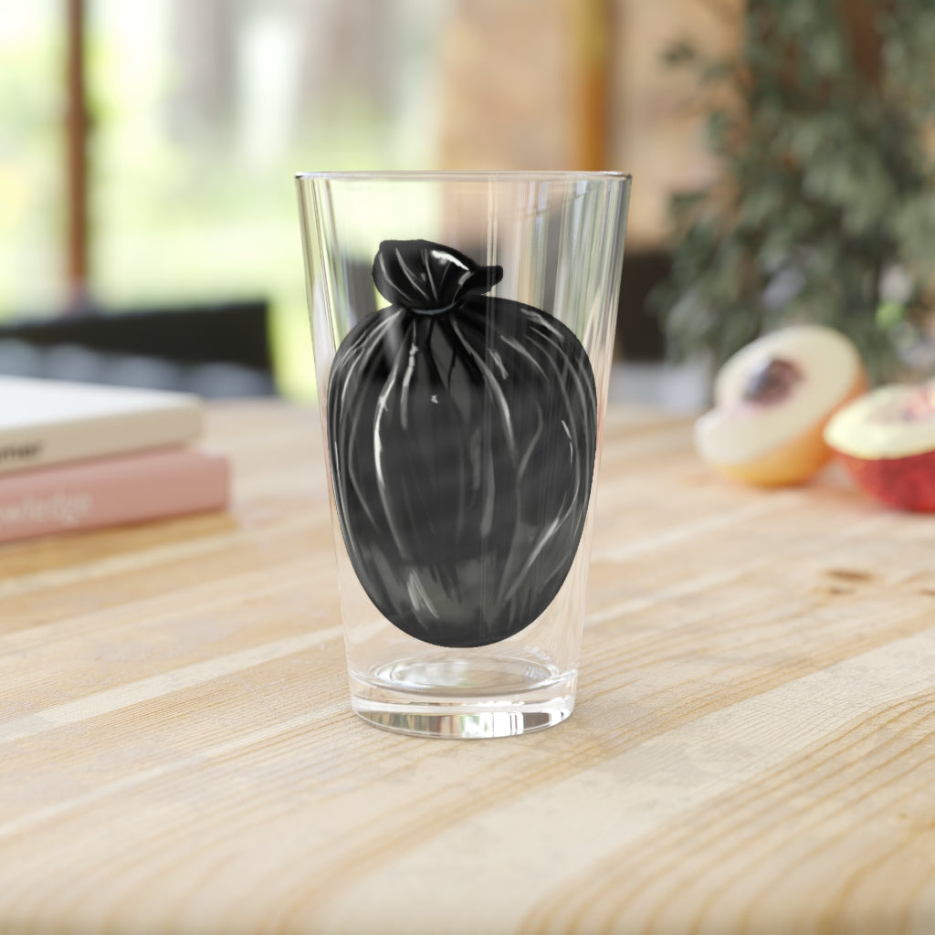 A clear 16oz Trash Bag Pint Glass showcasing a custom printed design, perfect for beverages.