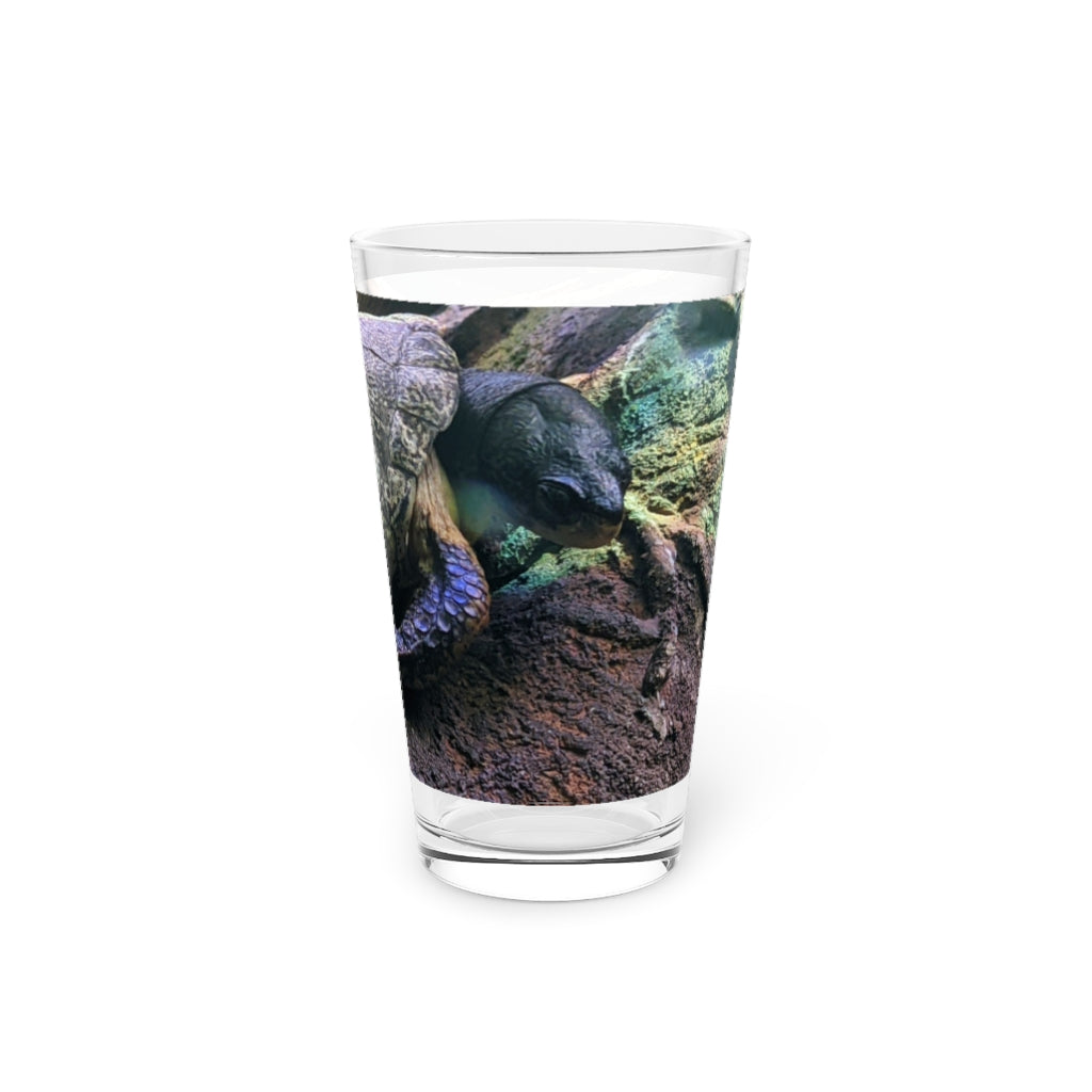 A clear 16oz Turtle Pint Glass showcasing a custom printed design, perfect for beverages.