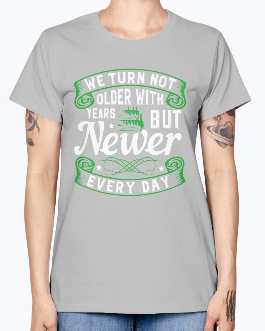 A stylish Missy T-Shirt featuring the quote 'We turn not older with years, but newer every day' in a vibrant color, perfect for birthday celebrations.