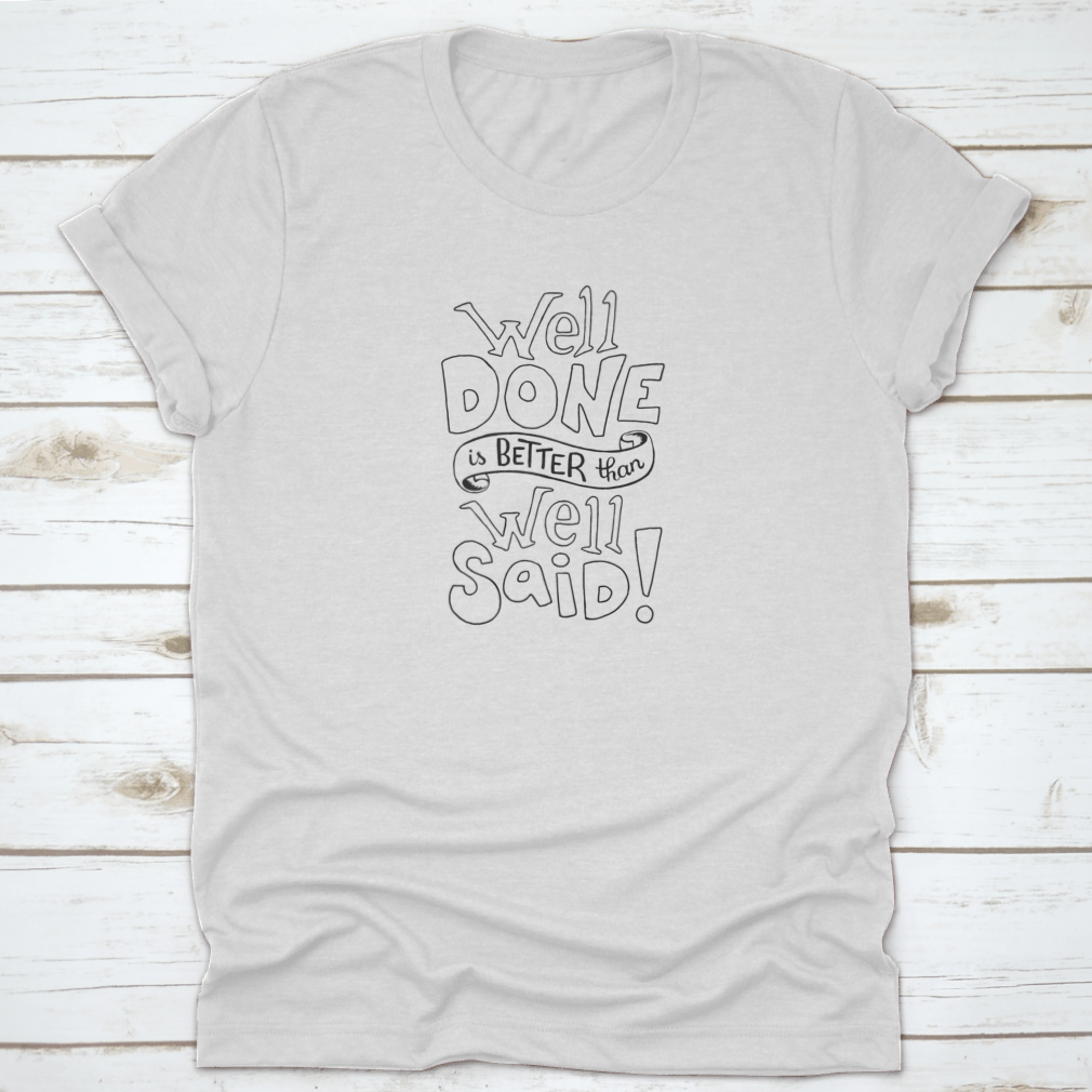 A motivational t-shirt featuring the quote 'Well Done Is Better Than Well Said', made from soft cotton fabric, displayed on a neutral background.