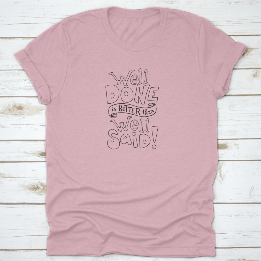 A motivational t-shirt featuring the quote 'Well Done Is Better Than Well Said', made from soft cotton fabric, displayed on a neutral background.