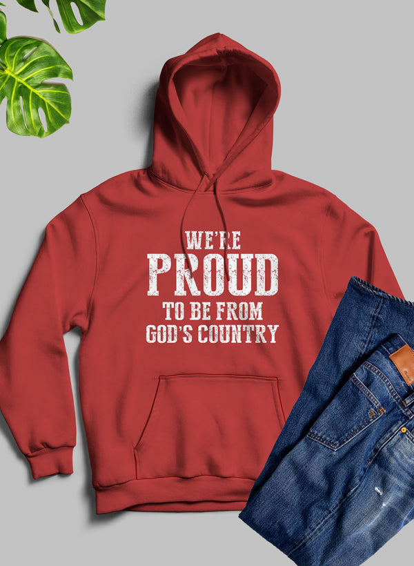 A cozy hoodie featuring the phrase 'We're Proud To Be From God's Country', designed with a fleece blend for warmth and comfort.