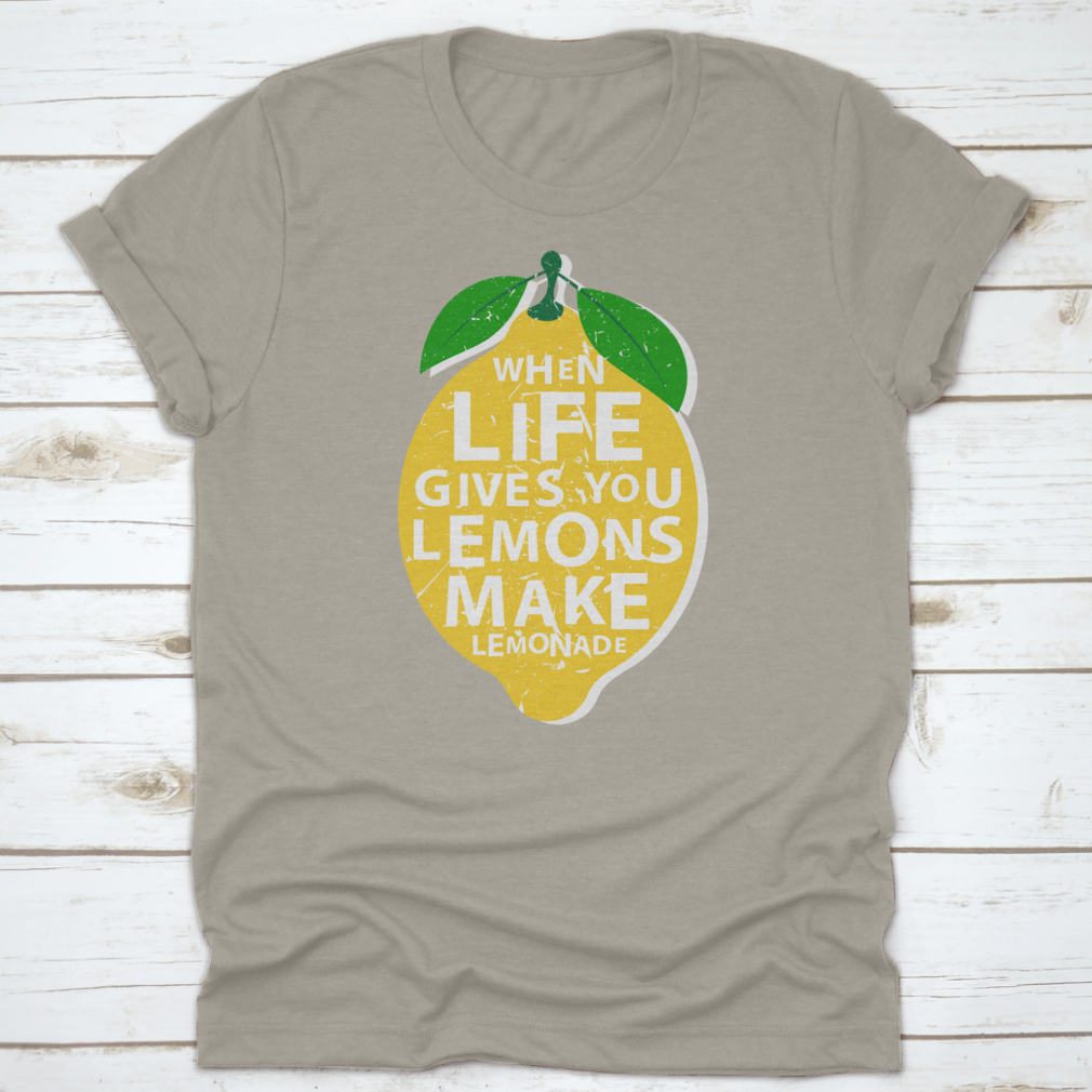 A motivational t-shirt featuring the phrase 'When Life Gives You Lemons, Make Lemonade' in a vibrant lemon-themed design.