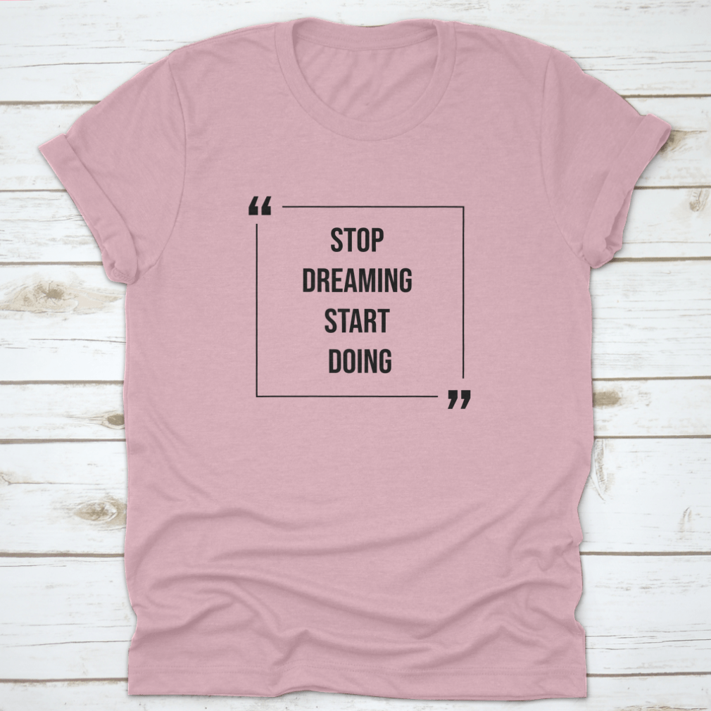 A motivational Word Shirt featuring the phrase 'Stop Dreaming Start', made from soft cotton fabric, displayed on a neutral background.