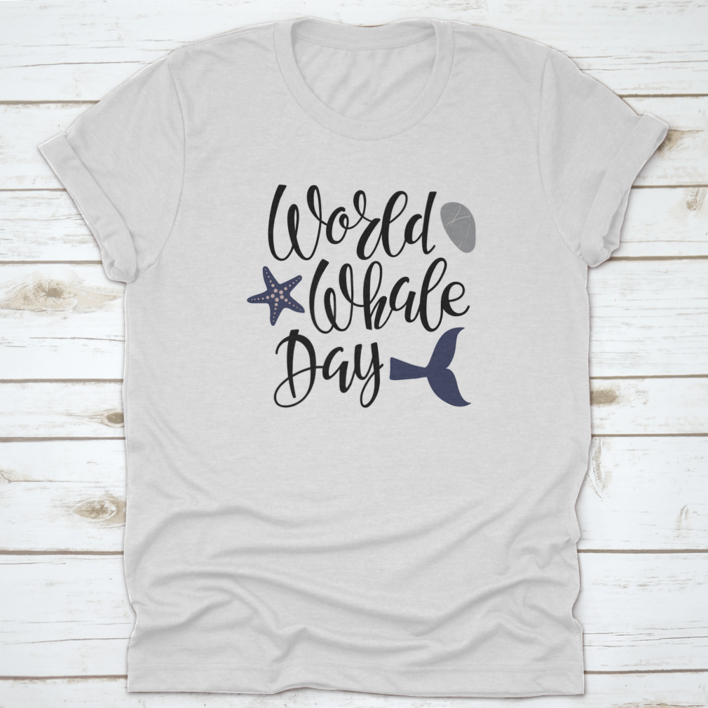 Handwritten calligraphy lettering design celebrating World Whale Day on a cotton apparel piece, showcasing marine life appreciation.