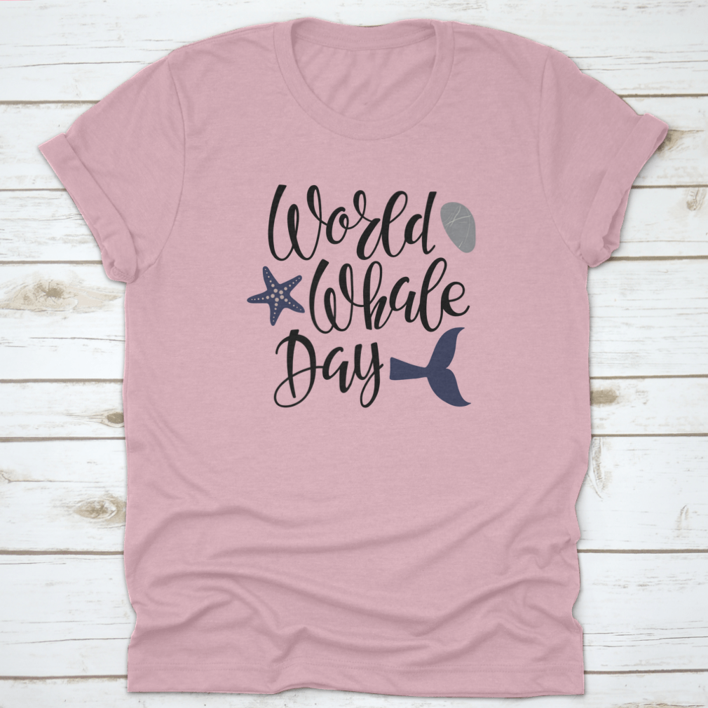 Handwritten calligraphy lettering design celebrating World Whale Day on a cotton apparel piece, showcasing marine life appreciation.