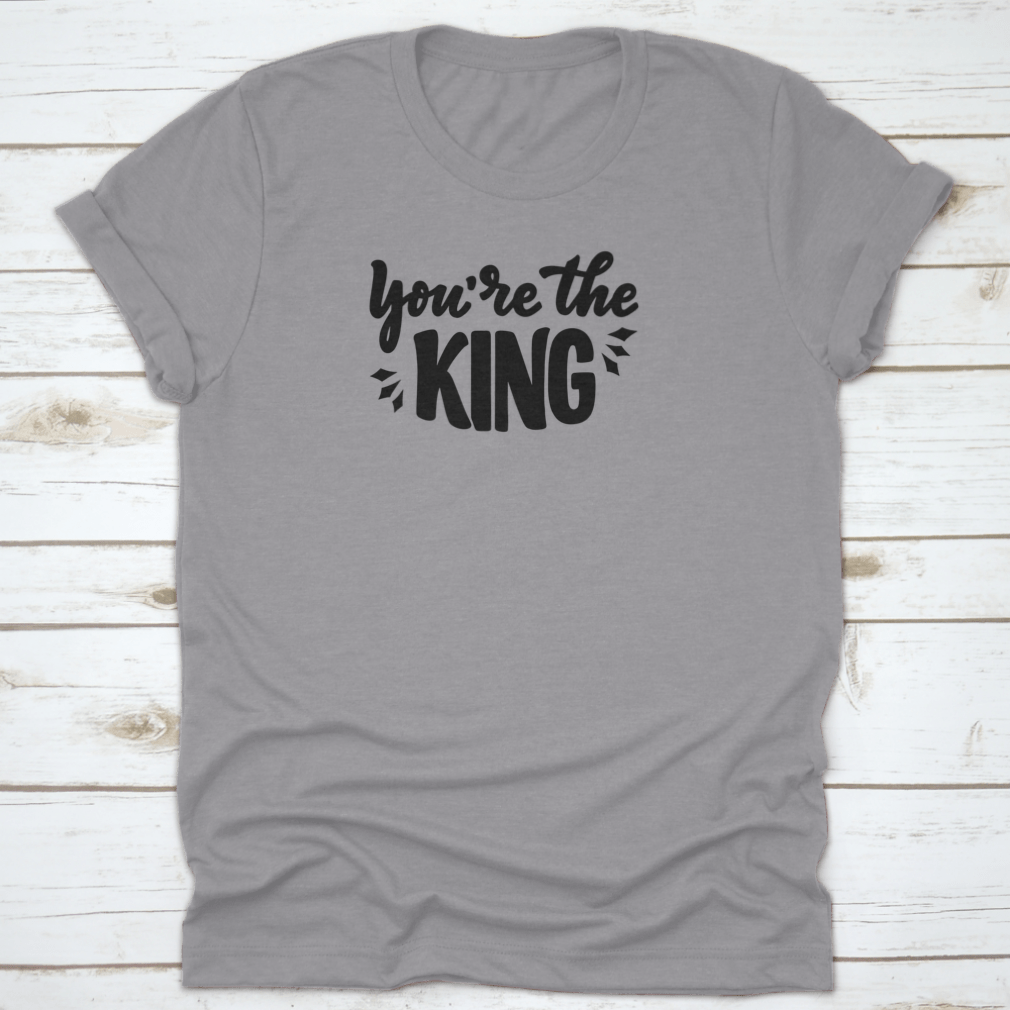 A stylish T-shirt featuring the hand-drawn phrase 'You're The King' in modern lettering, made from soft cotton fabric.