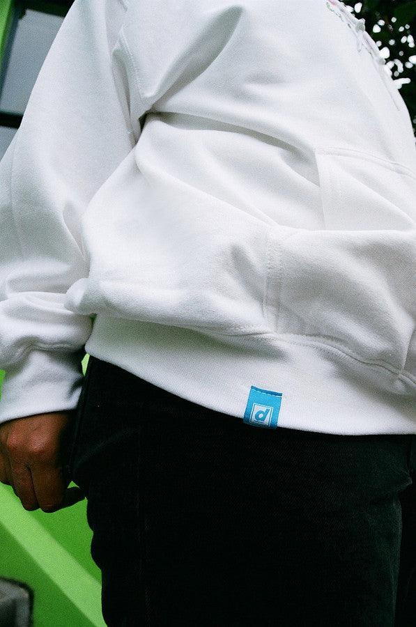 A white hoodie featuring a colorful 90s logo design with the text 'Dream But Do Not Sleep' printed on the front chest.