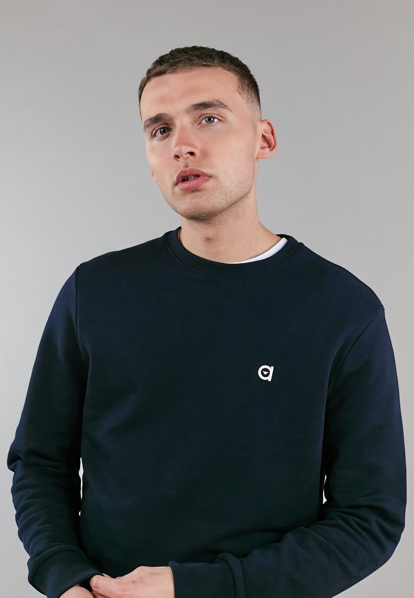 A stylish black crew neck sweatshirt made from 100% organic cotton, featuring an embroidered altid logo.