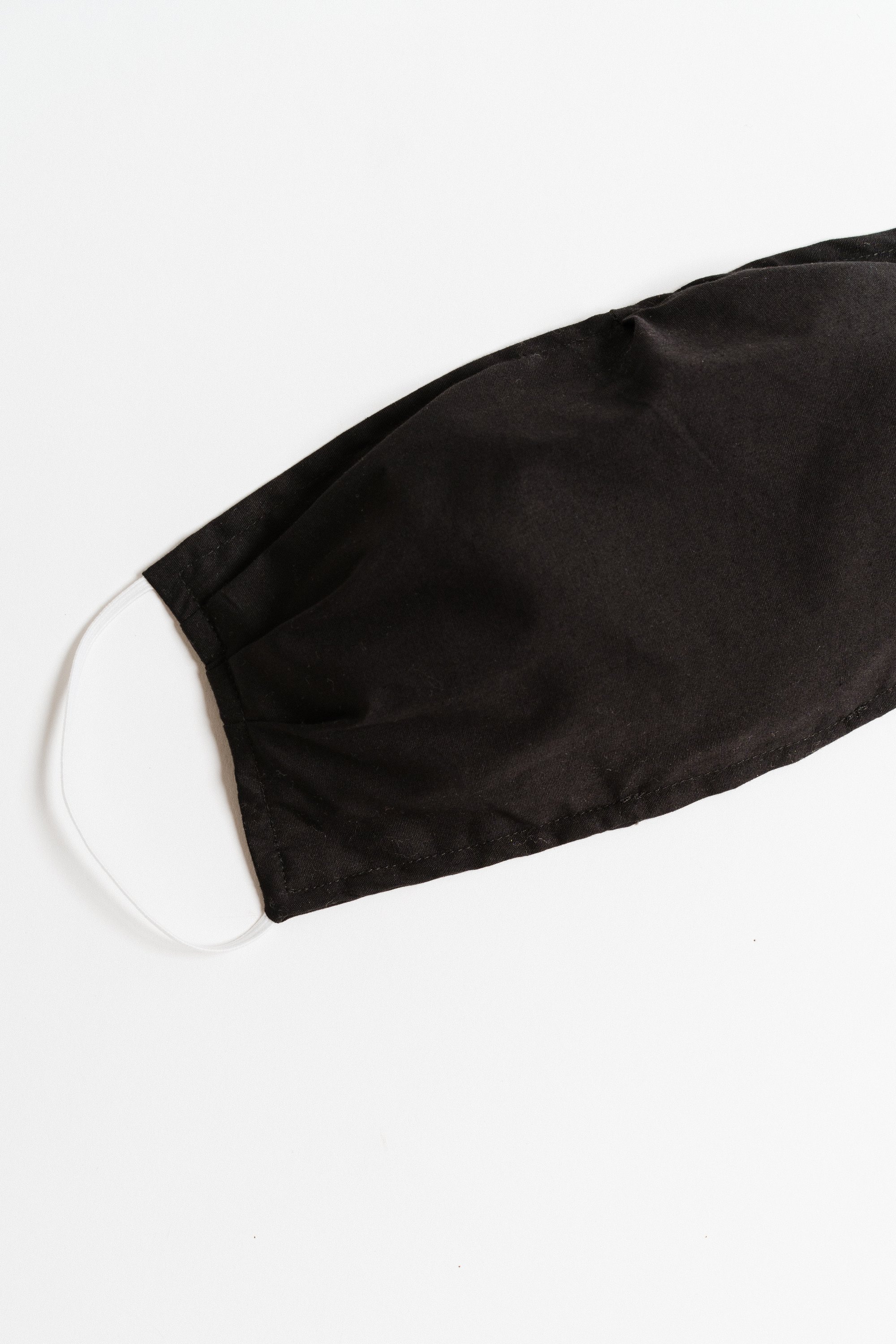 Black large face mask made of breathable cotton with pleats for comfort and a pocket for filters, suitable for everyday use.