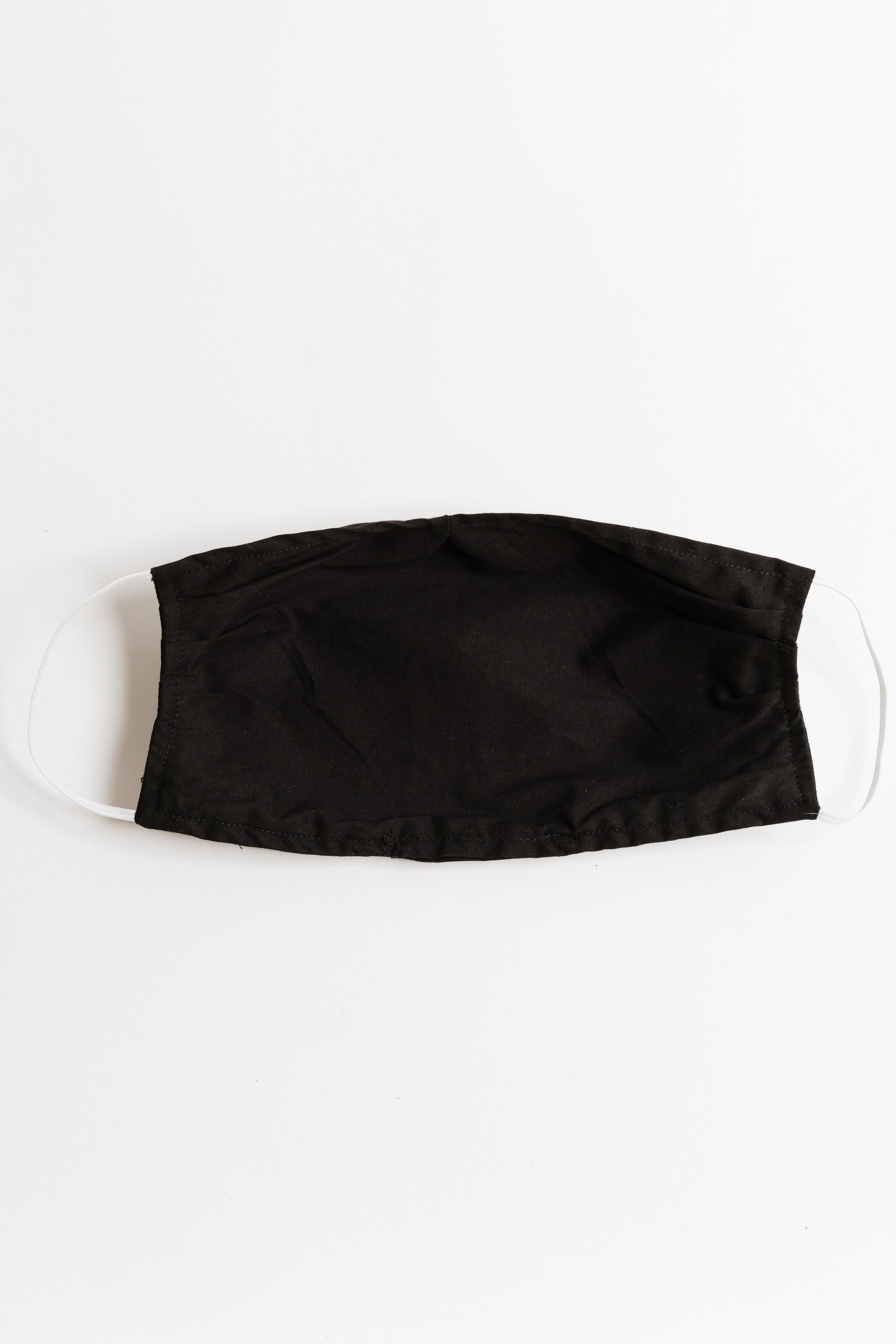 Black large face mask made of breathable cotton with pleats for comfort and a pocket for filters, suitable for everyday use.