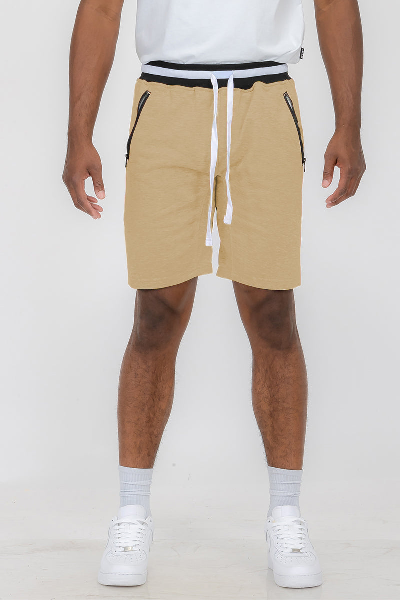 Man wearing tan drawstring shorts.