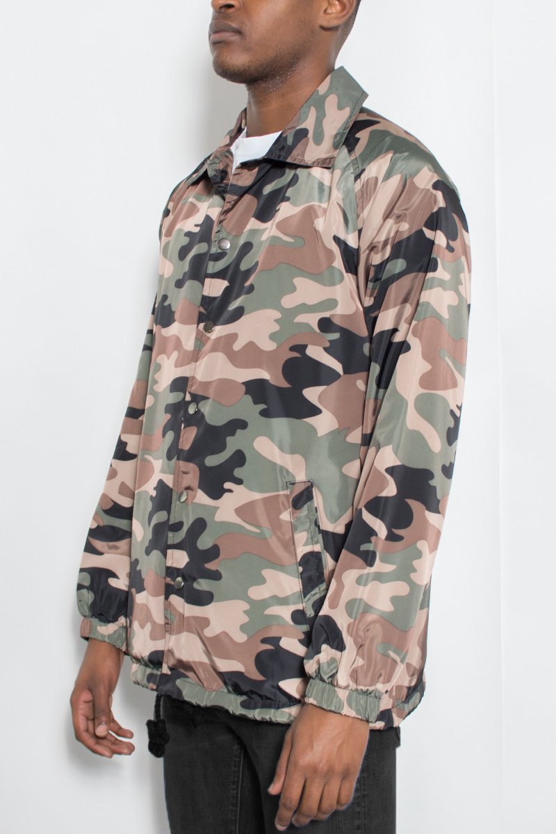 A stylish CAMO COACHS JACKET featuring a camouflage pattern, snap button closure, and multiple pockets, perfect for outdoor activities.