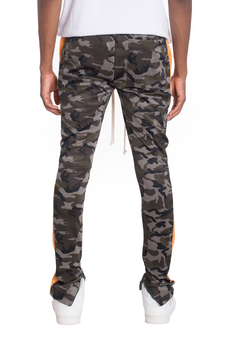 Camo side stripe track pants featuring a bold camouflage print, elastic waist, drawstring, and hidden ankle zipper.