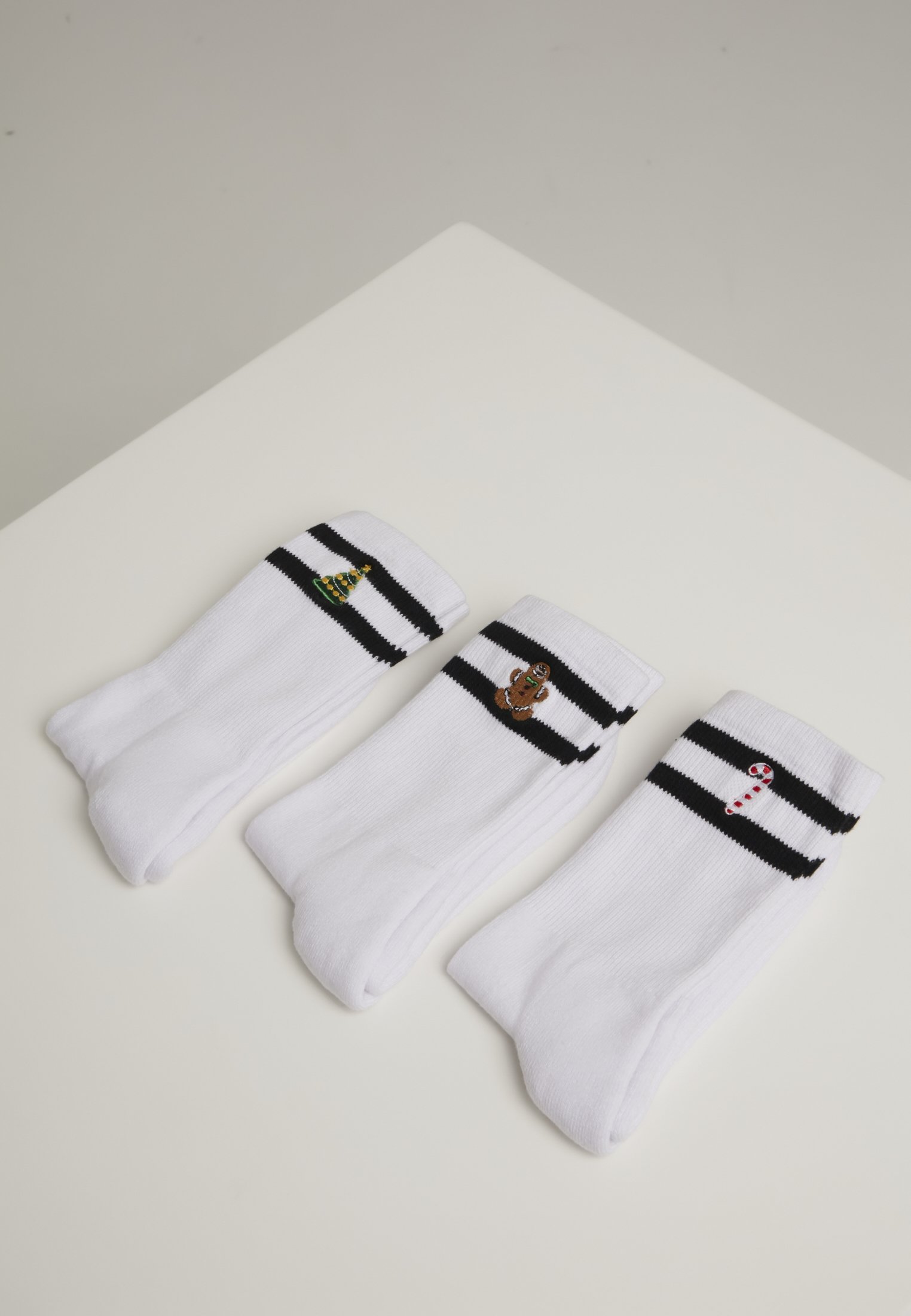 A set of three Christmas-themed sporty socks featuring a gingerbread man, lollipop, and Christmas tree designs, perfect for festive sports activities.