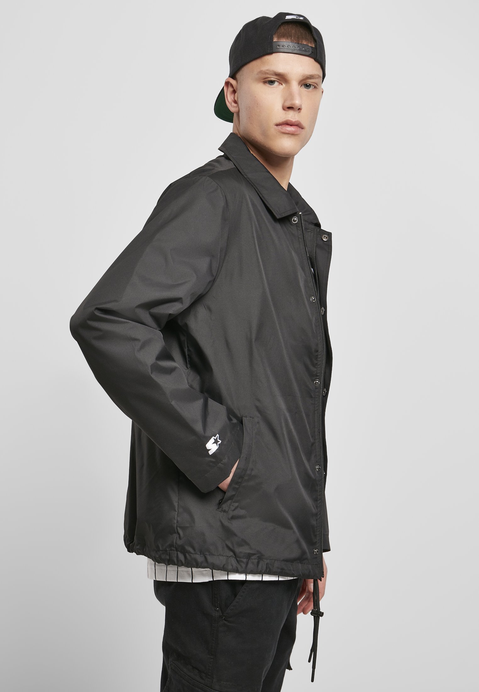 A stylish men's Coach Jacket featuring a minimalist design, hidden zipper, and STARTER logo on the chest, perfect for casual and sporty looks.