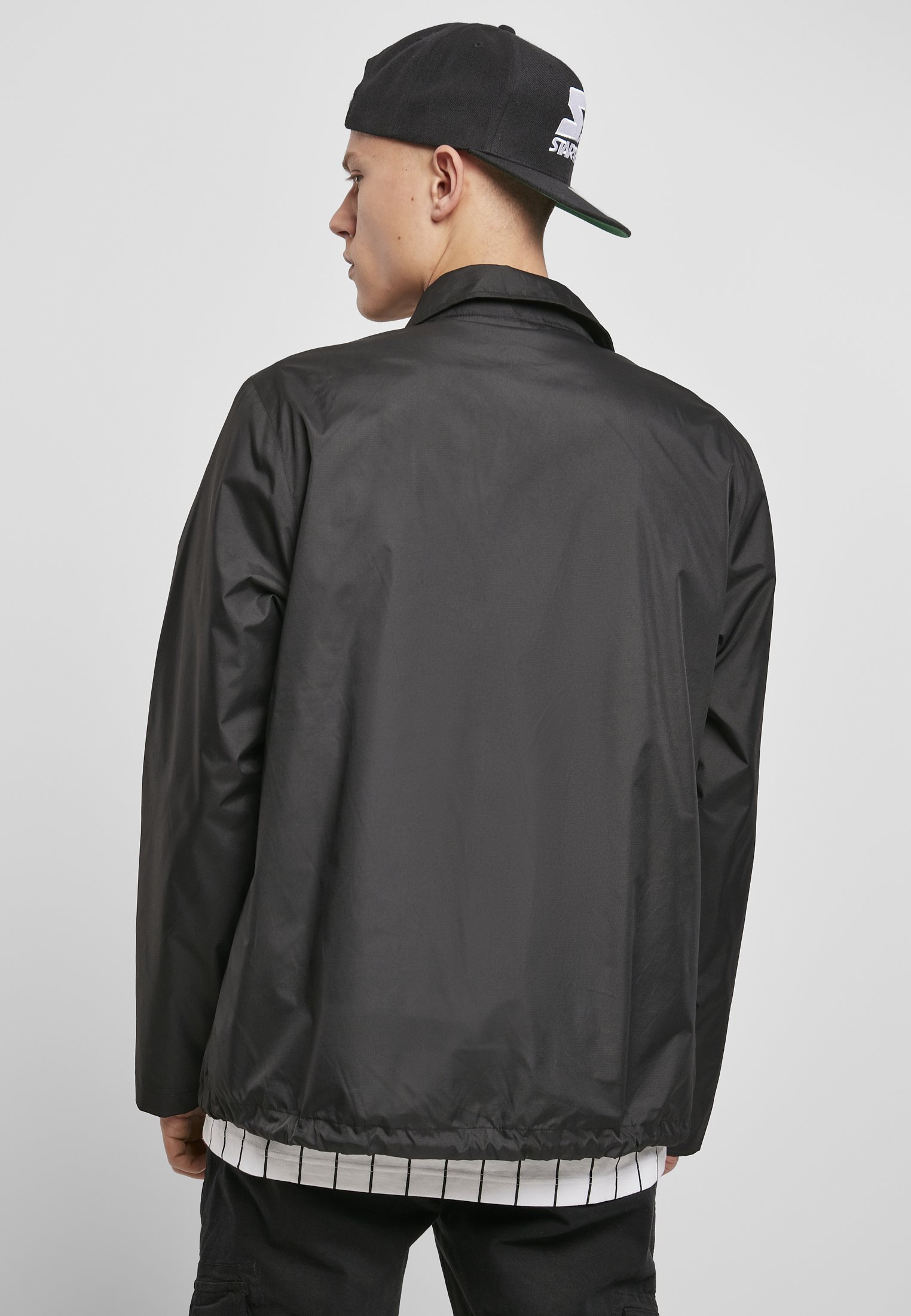 A stylish men's Coach Jacket featuring a minimalist design, hidden zipper, and STARTER logo on the chest, perfect for casual and sporty looks.