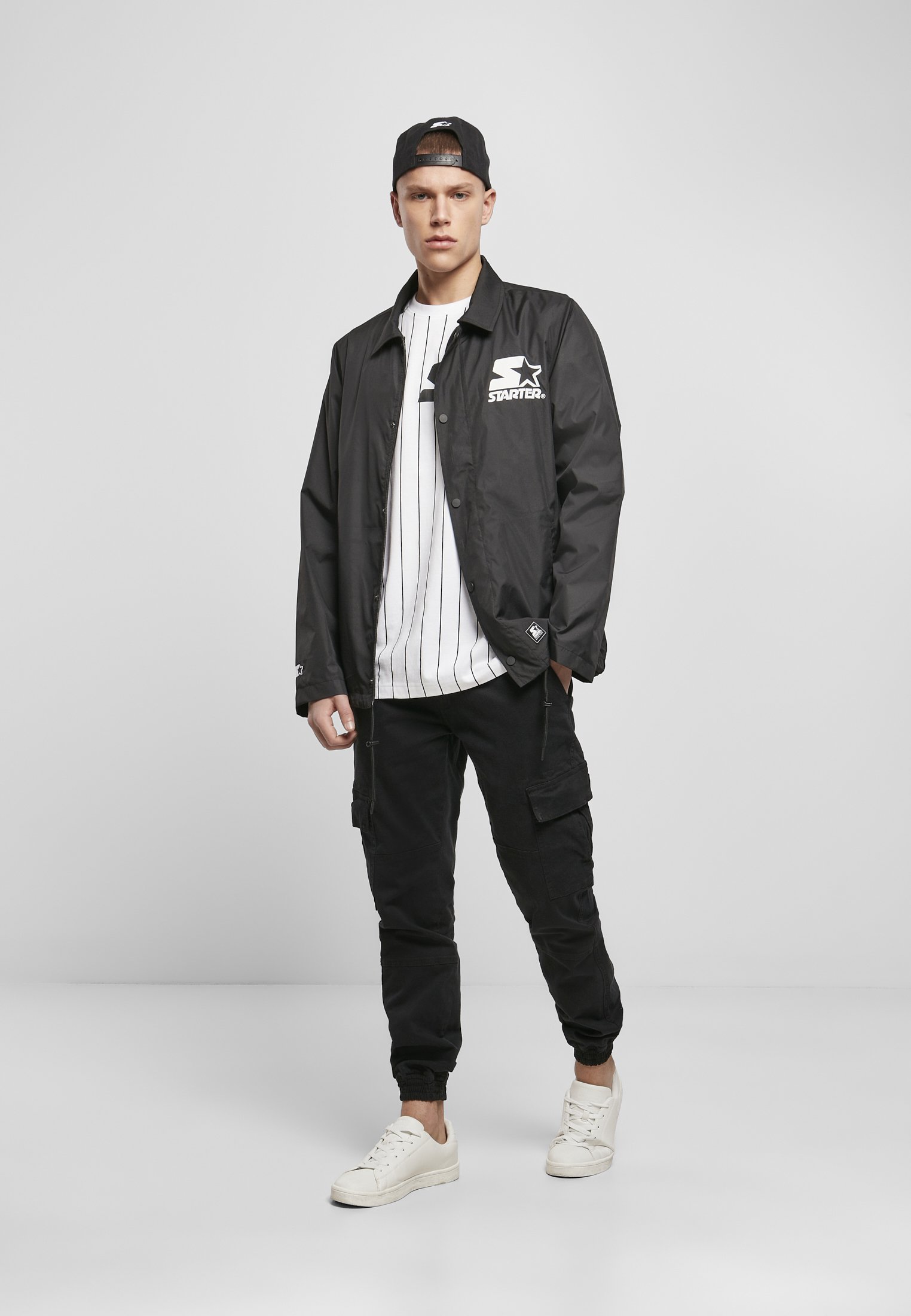 A stylish men's Coach Jacket featuring a minimalist design, hidden zipper, and STARTER logo on the chest, perfect for casual and sporty looks.