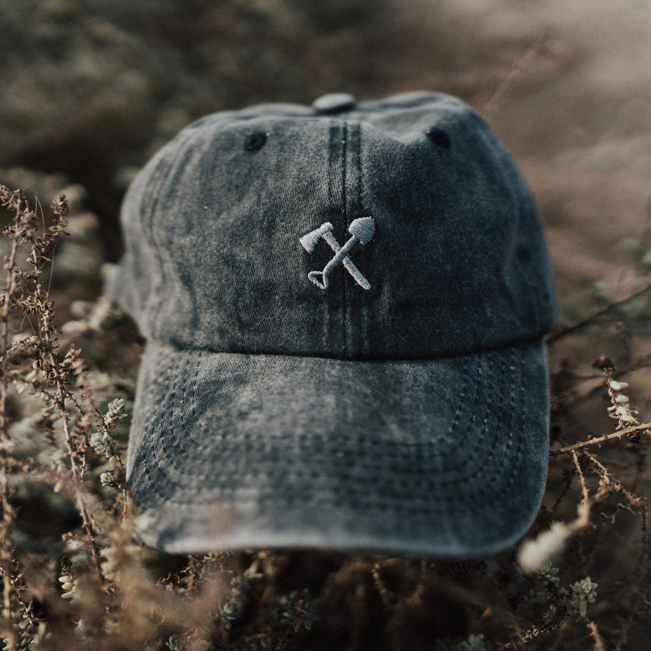 Cody Dad Hat featuring a curved brim, snow-washed finish, and embroidered shovel and ax logo, designed for comfort and style.